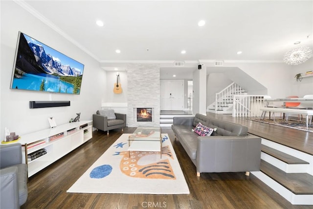 living area with crown molding, recessed lighting, visible vents, a fireplace, and wood finished floors