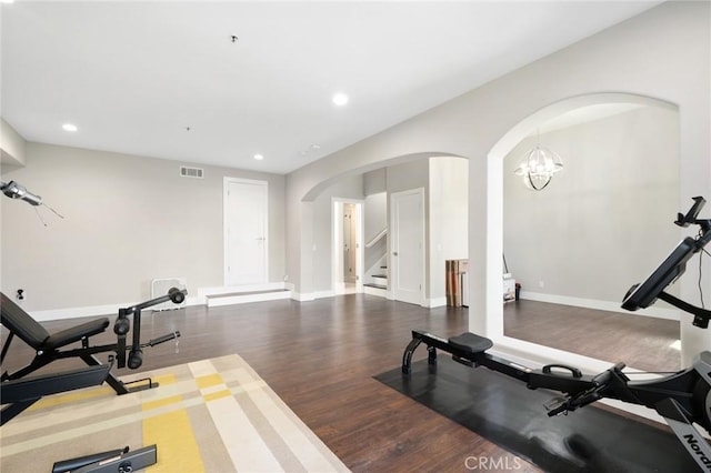 exercise area featuring recessed lighting, baseboards, arched walkways, visible vents, and wood finished floors