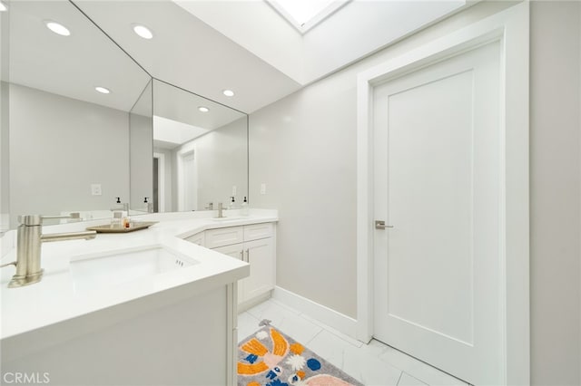 bathroom featuring marble finish floor, double vanity, recessed lighting, and a sink