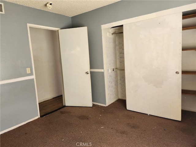 unfurnished bedroom featuring carpet flooring, visible vents, a closet, and a textured ceiling