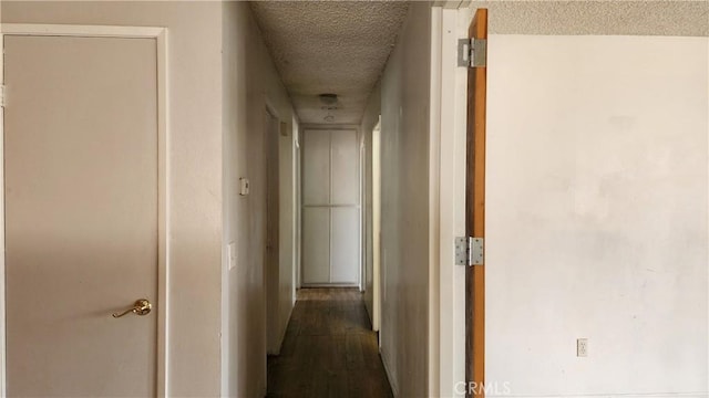 hall featuring dark wood-type flooring and a textured ceiling