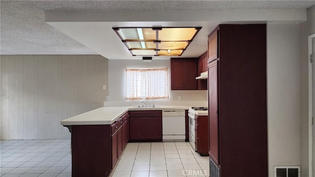 kitchen featuring white appliances, light tile patterned floors, a sink, visible vents, and a peninsula