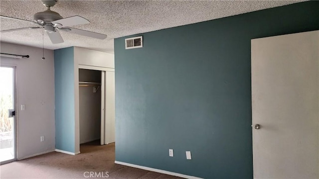 unfurnished bedroom with carpet flooring, baseboards, a textured ceiling, visible vents, and a closet