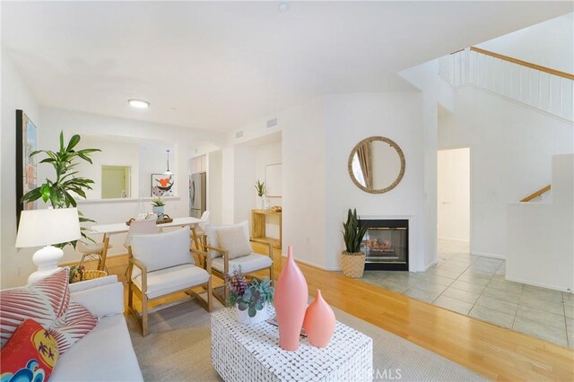 1510 Timberwood, Irvine, CA 92620 - living area with light wood-style flooring, stairs, and a glass covered fireplace