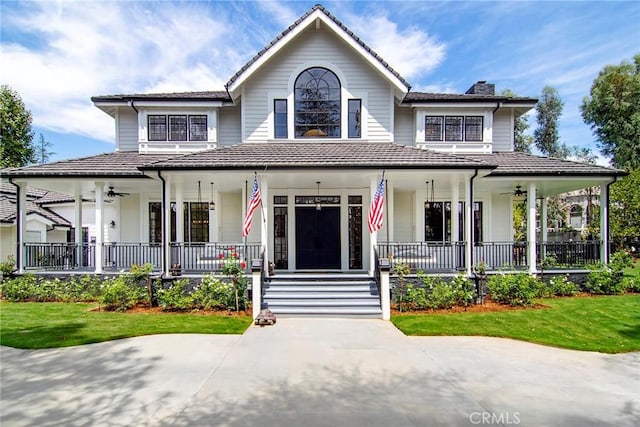 view of front facade featuring a chimney, a front yard, and a porch