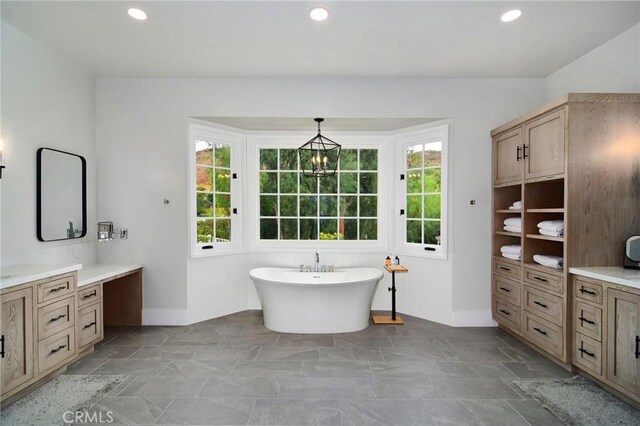 full bath featuring recessed lighting, a soaking tub, and vanity
