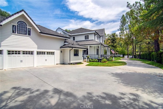 view of front of property featuring covered porch, concrete driveway, and a garage