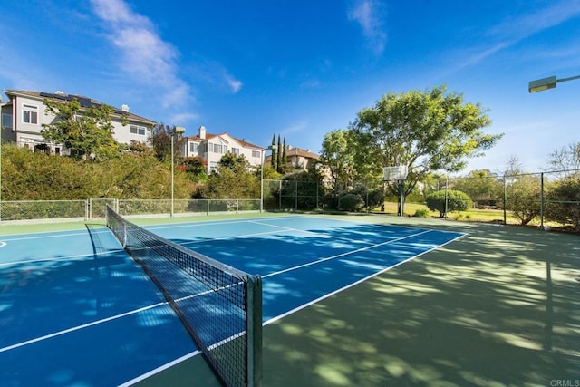view of sport court with a residential view and fence