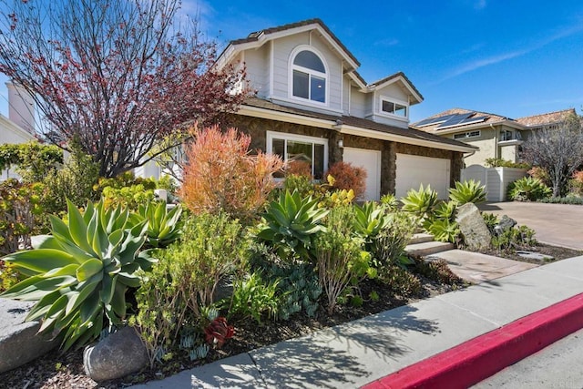 view of front of house with driveway and stone siding