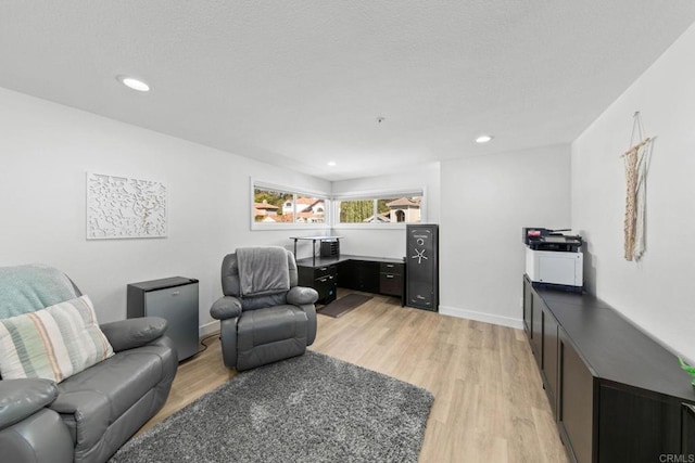 living room with baseboards, light wood finished floors, and recessed lighting