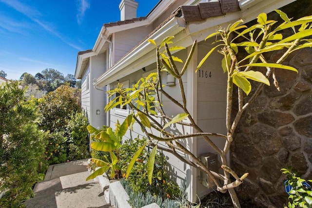 1164 Quail Gardens Ct, Encinitas, CA 92024 - view of home's exterior featuring a chimney and stone siding
