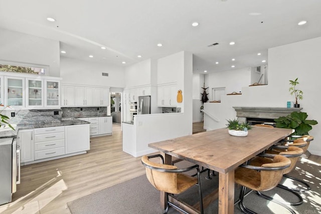 1164 Quail Gardens Ct, Encinitas, CA 92024 - dining space with recessed lighting, light wood-type flooring, a high ceiling, and stairs