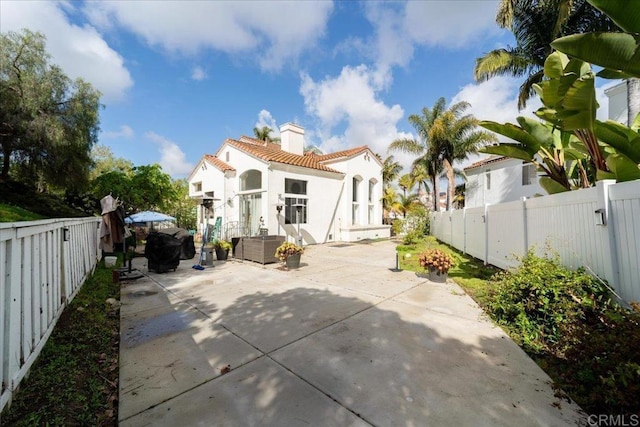 4981 Marin Dr, Oceanside, CA 92056 - rear view of house featuring a fenced backyard, a patio, a tiled roof, and a chimney