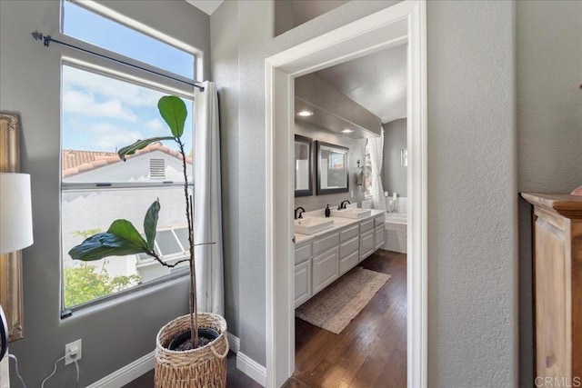 4981 Marin Dr, Oceanside, CA 92056 - full bathroom with double vanity, wood finished floors, and a textured wall