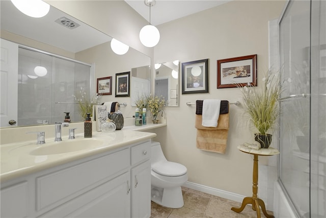 bathroom with toilet, vanity, a shower with door, baseboards, and visible vents