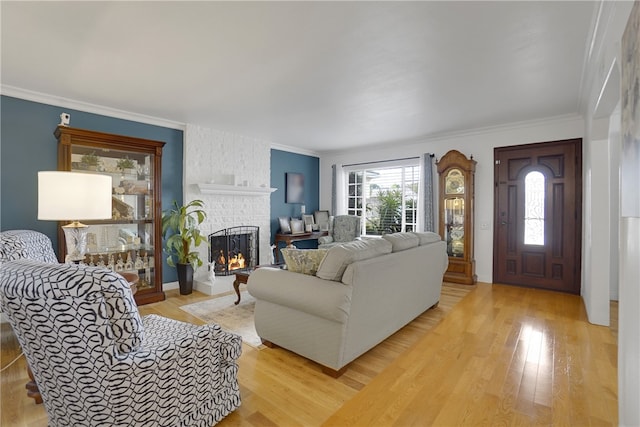living room featuring a fireplace, light wood-type flooring, and ornamental molding