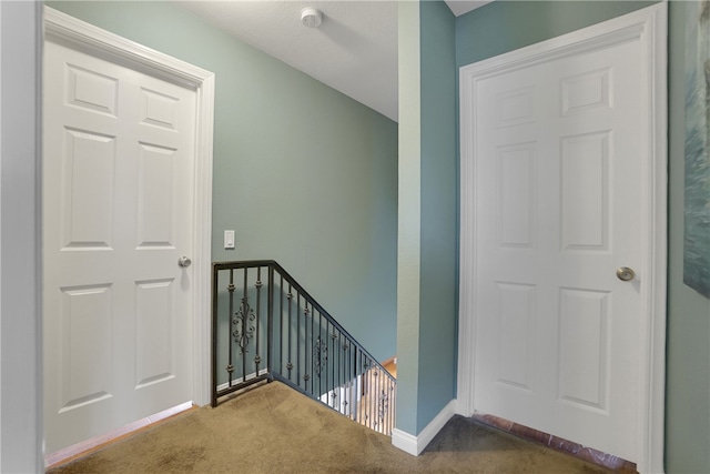 stairway with baseboards and carpet flooring
