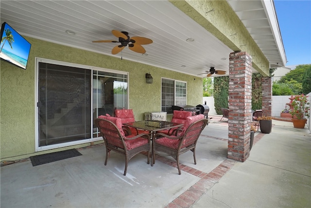 view of patio featuring fence, outdoor dining space, and ceiling fan