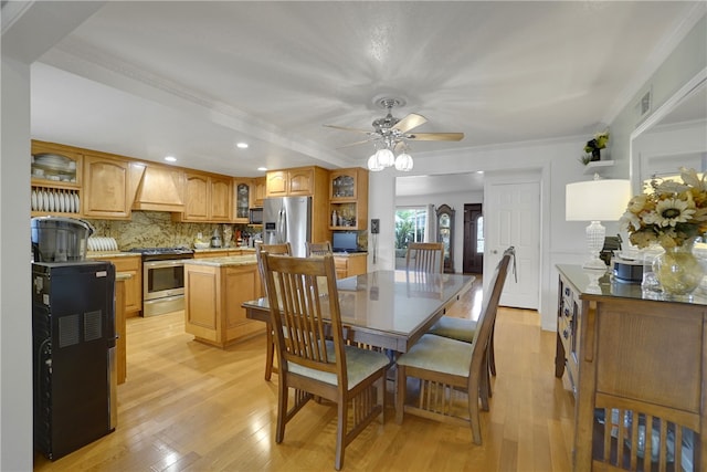 dining space with ornamental molding, visible vents, light wood-style floors, and a ceiling fan