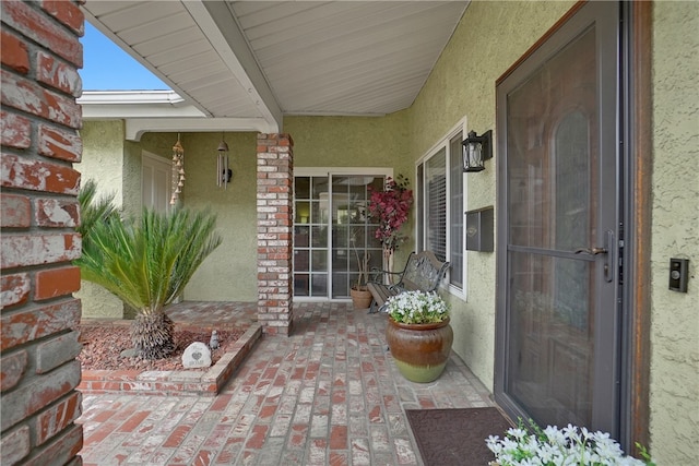 property entrance with stucco siding and stone siding