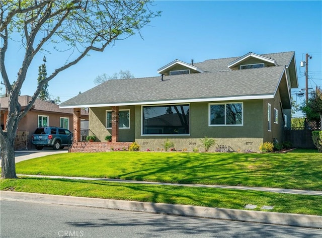 single story home with a shingled roof, stucco siding, and a front yard
