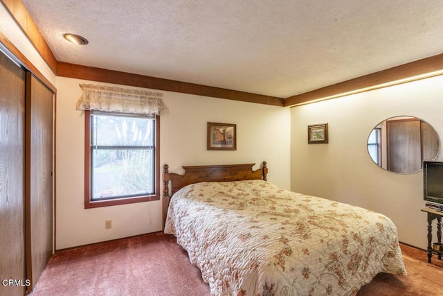 bedroom with a closet, carpet floors, and a textured ceiling