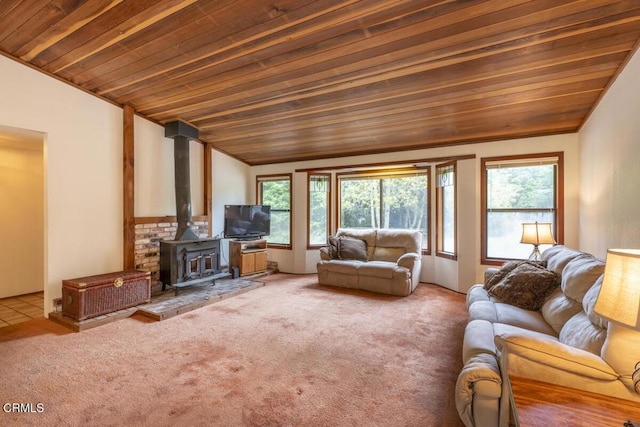 unfurnished living room featuring lofted ceiling, wood ceiling, carpet flooring, and a wood stove