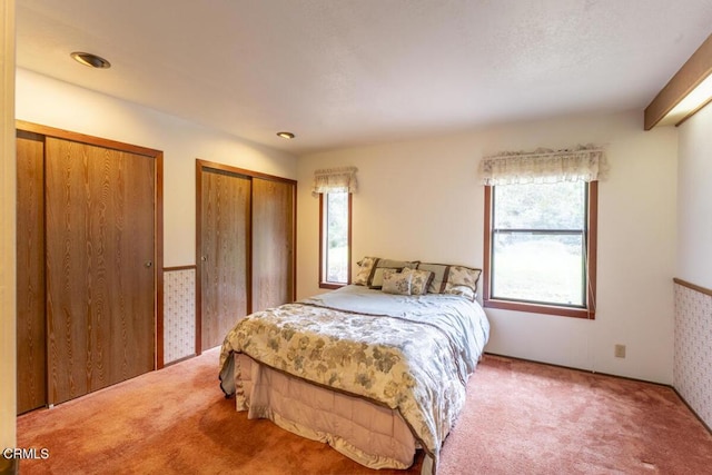 bedroom featuring two closets and carpet flooring