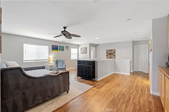 living area with baseboards, a ceiling fan, recessed lighting, and light wood finished floors