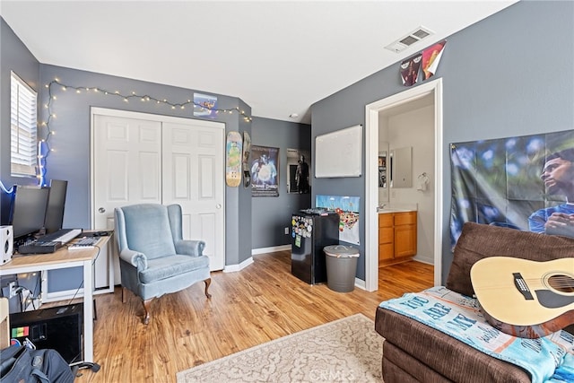 living area featuring visible vents, baseboards, and light wood-type flooring