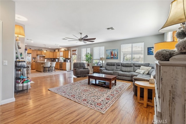 living area featuring light wood finished floors, a ceiling fan, visible vents, and recessed lighting