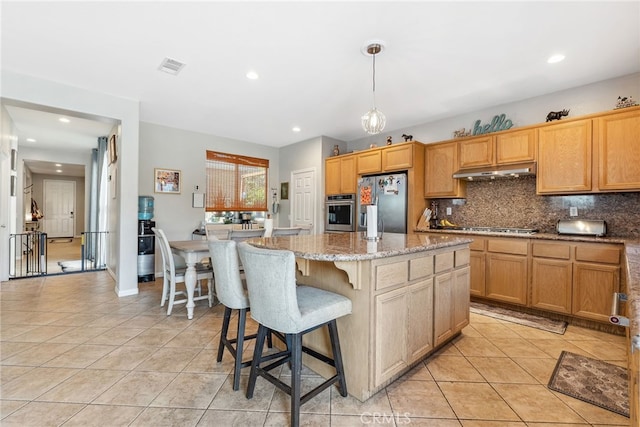 kitchen with tasteful backsplash, light tile patterned floors, under cabinet range hood, visible vents, and stainless steel appliances