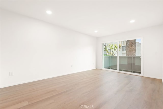 empty room with light wood finished floors, baseboards, and recessed lighting