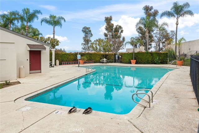 community pool featuring a patio area and fence