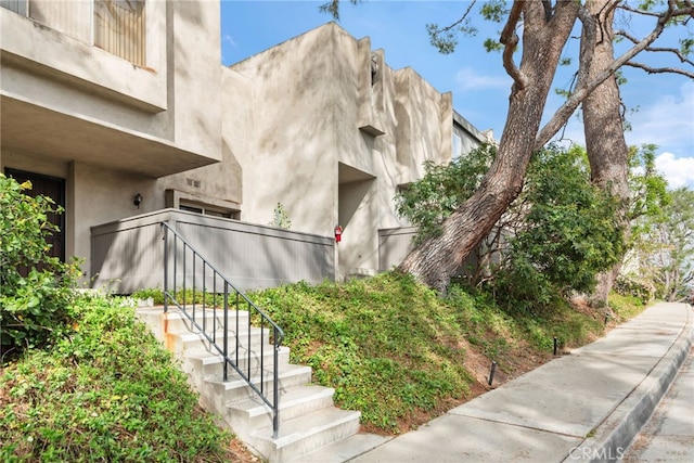 view of home's exterior with stairs and stucco siding