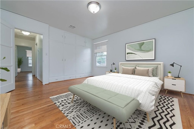 bedroom with visible vents, a closet, and light wood-style floors