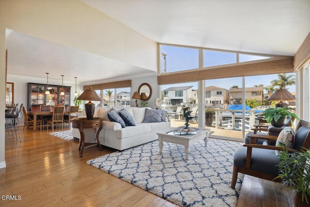 2231 Peninsula Rd, Oxnard, CA 93035 - living room featuring high vaulted ceiling, ornamental molding, and hardwood / wood-style floors