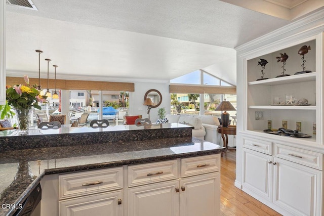 2231 Peninsula Rd, Oxnard, CA 93035 - kitchen featuring white cabinets, light wood-type flooring, dark stone countertops, open floor plan, and ornamental molding