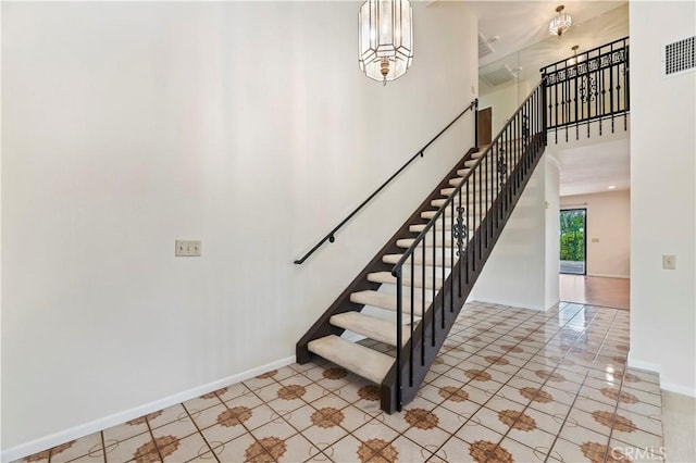 15705 Gila Way, Riverside, CA 92508 - staircase featuring visible vents, baseboards, a towering ceiling, and tile patterned floors
