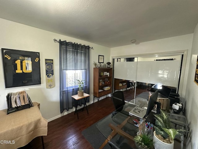 living area featuring a textured ceiling, wood finished floors, and baseboards