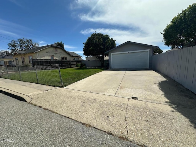 exterior space with a front yard, a detached garage, an outdoor structure, and fence private yard