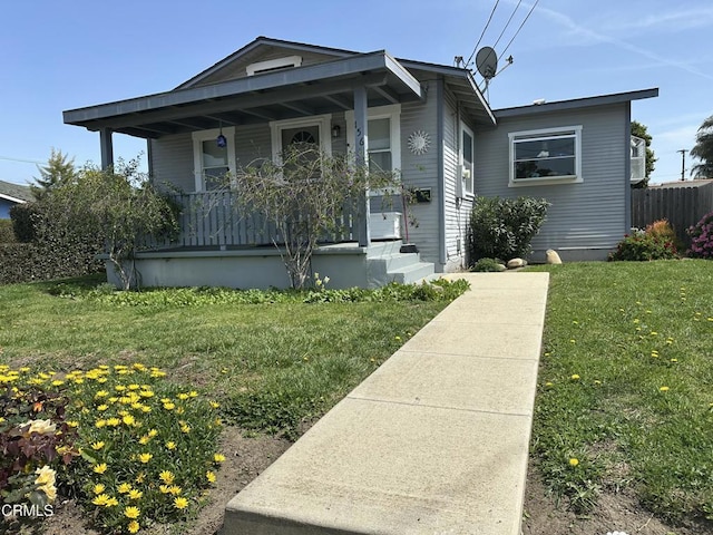 view of front of property with a front yard, a porch, and fence