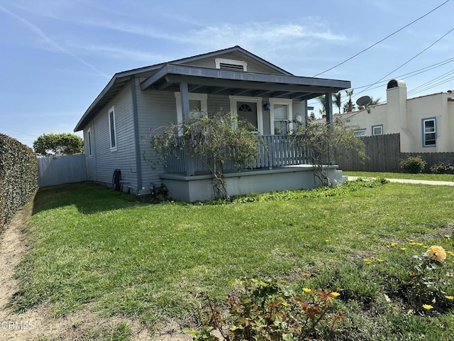 view of front of house with a porch, fence, and a front lawn