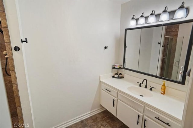 full bathroom featuring a shower stall, vanity, baseboards, and tile patterned floors