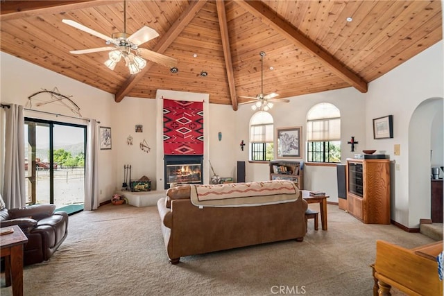 5420 Clayvale St, Acton, CA 93510 - living area with a tiled fireplace, carpet, arched walkways, a ceiling fan, and beamed ceiling