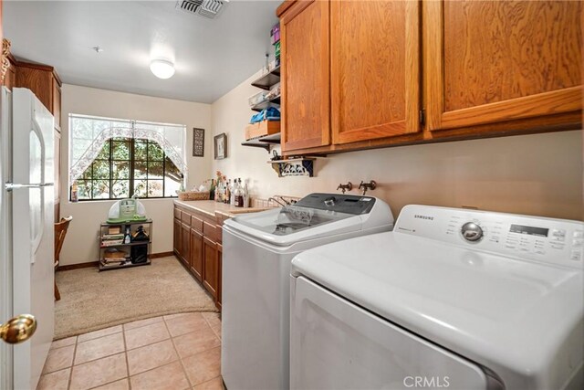 5420 Clayvale St, Acton, CA 93510 - laundry area featuring light colored carpet, washing machine and clothes dryer, light tile patterned floors, cabinet space, and baseboards