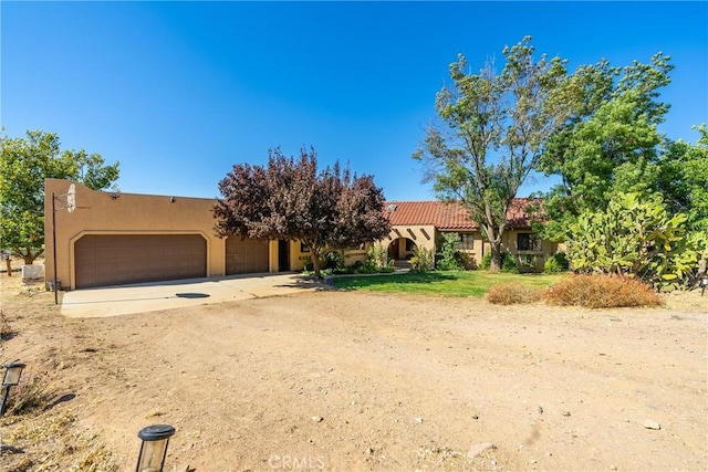 5420 Clayvale St, Acton, CA 93510 - view of front of house with stucco siding, an attached garage, dirt driveway, and a tiled roof