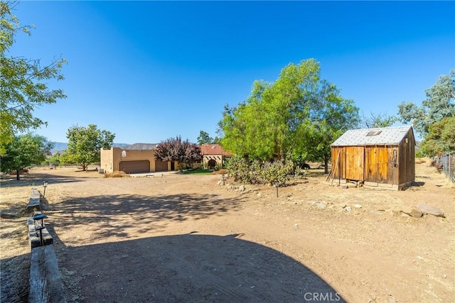 5420 Clayvale St, Acton, CA 93510 - view of yard featuring a storage unit, an outdoor structure, an attached garage, and fence