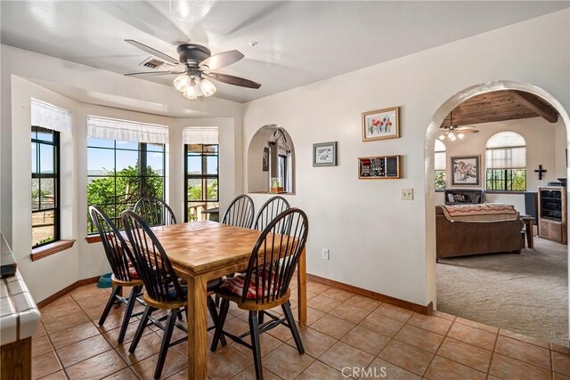 5420 Clayvale St, Acton, CA 93510 - dining space featuring ceiling fan, light tile patterned floors, baseboards, arched walkways, and light carpet