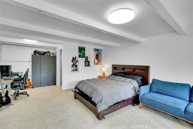 bedroom featuring beam ceiling and baseboards